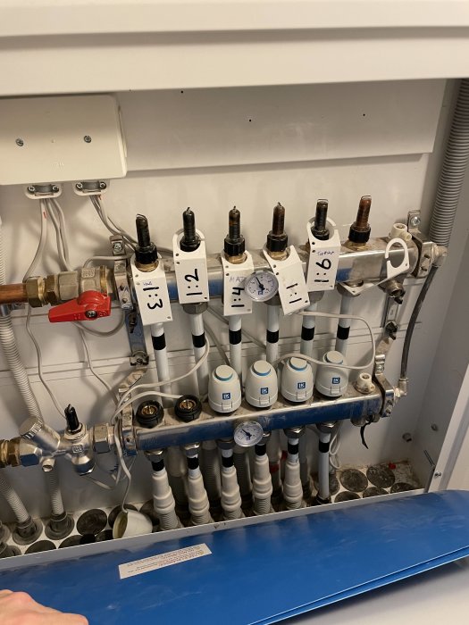 Värmerörsystem med numrerade ventiler och termostater, tryckmätare, kopplingar och elanslutningar.