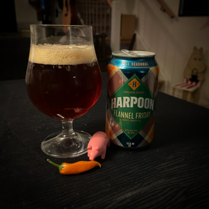Öl i glas bredvid burk, leksaksgris, chili, inomhusmiljö, "Harpoon Flannel Friday" etikett.