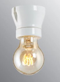 Glödlampa med glödtrådar synliga, tänd, mot grå bakgrund, inomhus, modern belysningsteknik.