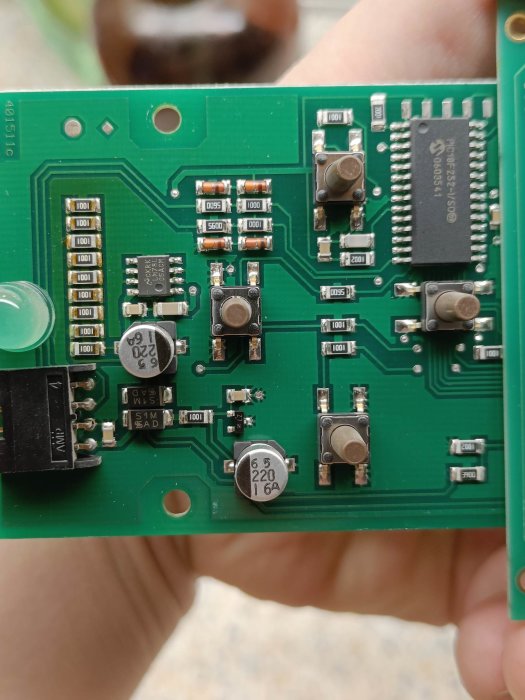 Kretskort med integrerade kretsar, kondensatorer, motstånd, och tryckknappar; teknologisk komponent, grönt PCB.