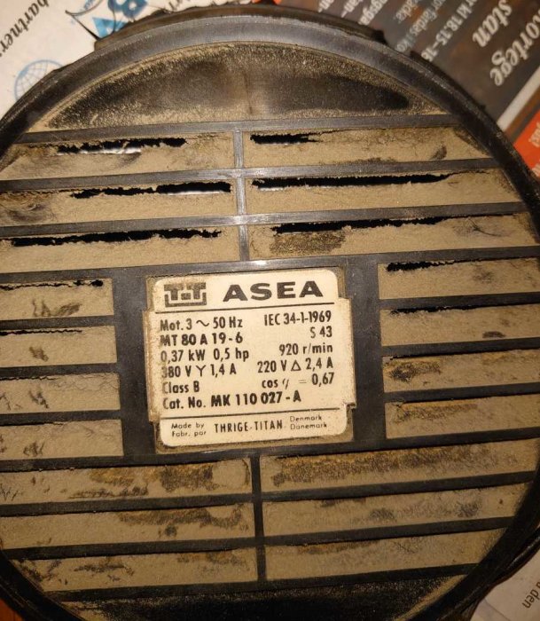 Motor med typskylt, ASEA-logotyp, tekniska specifikationer, dammig yta, industriell utrustning. Made in Denmark.