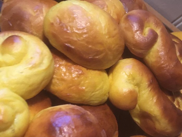 Nybakade, gyllenbruna bullar med blank yta, troligen söta, varierande former, fluffiga, frestande till fika.