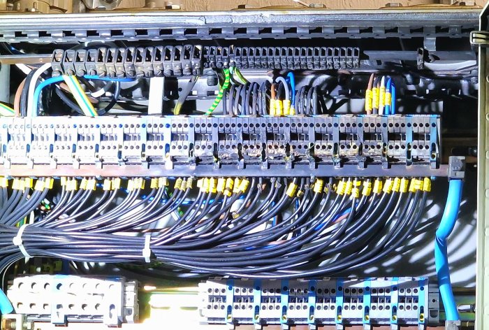 Ett organiserat kabelhanteringssystem och elektriska anslutningar i en industriell eller nätverksutrustningsinställning.