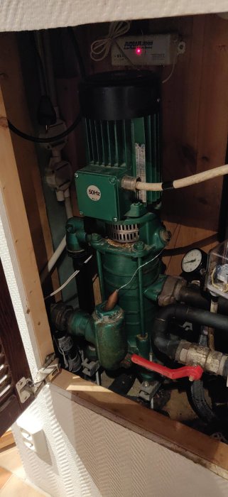 Vattenpump i ett skåp, rör, ledningar, mätare, elektrisk utrustning, underhållsutrymme, ventil, 50Hz-märkning.