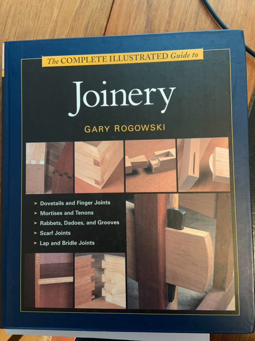 Bok om träarbete, "The Complete Illustrated Guide to Joinery" av Gary Rogowski, visar träfogar.