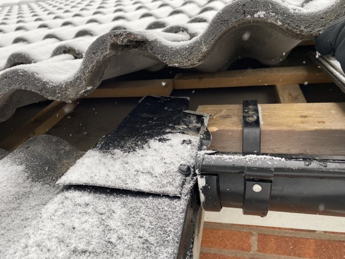 Takpannor, snö, takrinna, träsparrar, snöfall, byggkonstruktion, delvis öppen takyta, kalla väderförhållanden.