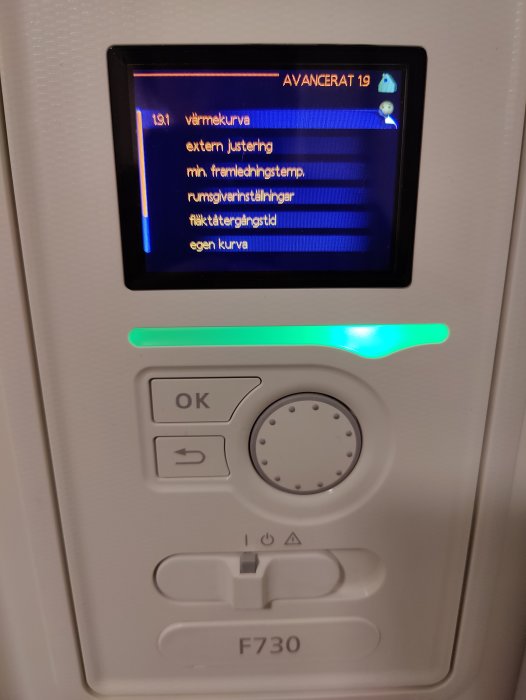 Digital kontrollpanel för värmesystem, med menyval visade på svenska, modell F730, grön statusindikator aktiverad.