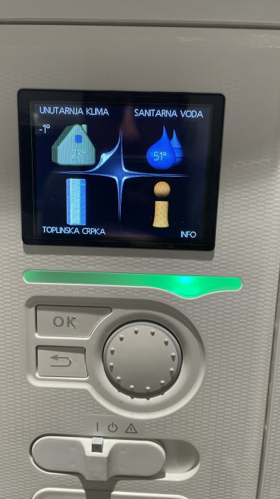 Kontrollpanel för värme och vatten, visar temperaturer och inställningar, grå bakgrund, knappar, grön indikatorljus.