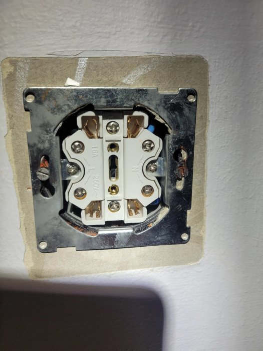Öppen eluttag, saknar kåpa, exponerade ledningar, installationsfas, säkerhetsrisk, vägg, oavslutat elektriskt arbete.