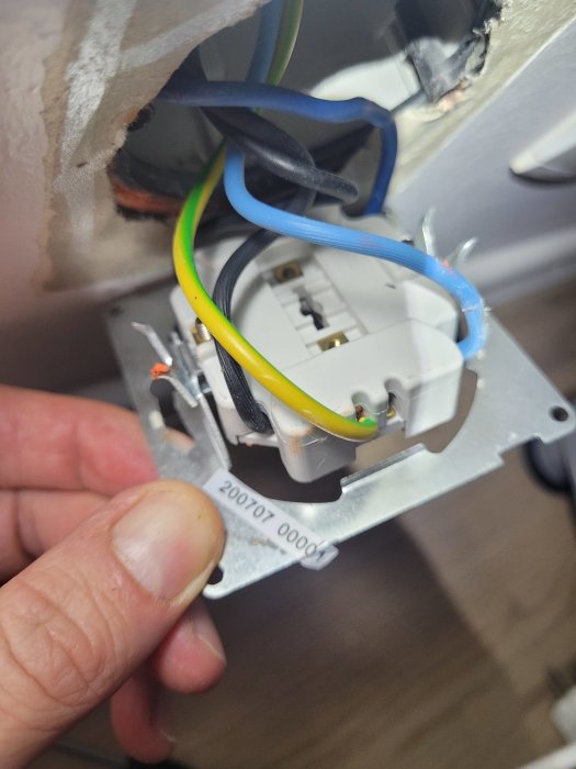Elektrisk installation, eluttag, oanslutna kablar, hand installerar, säkerhetsrisk, oskarp förgrund, inomhus, arbetsprocess.