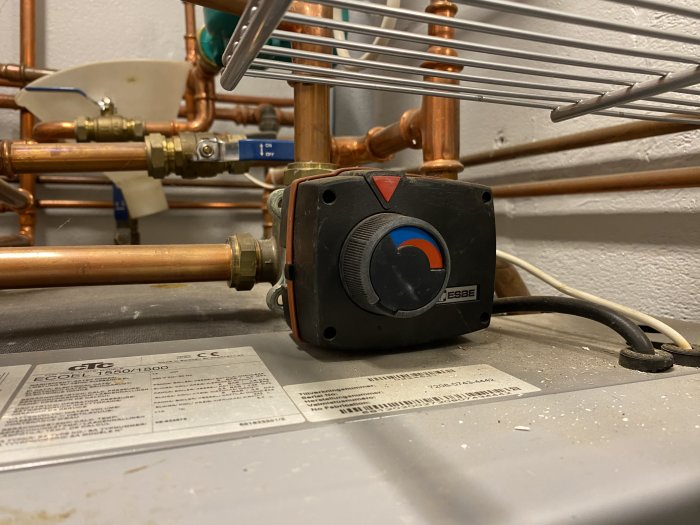 Värmesystem med cirkulationspump, kopparledningar, etiketter, temperaturinställning, installation i hemmiljö.