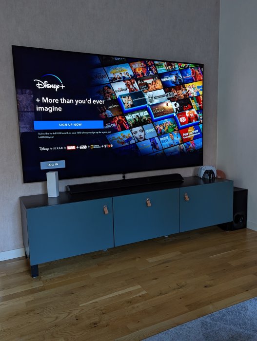 TV-skärm visar Disney+ streamingtjänstens startsida med många titlar, i ett modernt vardagsrum.