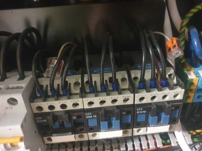 Elektriskt installationsskåp med kontakter, ledningar och märkningar, industriellt och tekniskt utseende.