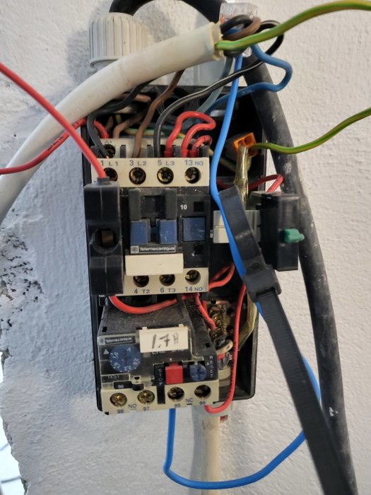 Oorganiserad elektrisk installation med sladdar och kontakter, utsatt och potentiellt osäker.