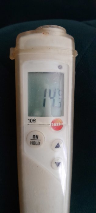 Digital termometer visar 14 grader Celsius, knappar, "ON HOLD", använd, smutsiga fläckar synliga.