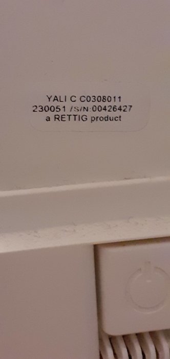 Etikett på radiator, "YALI C", serienummer, "RETTIG-produkt", vit, struktur, elektrisk symbol.