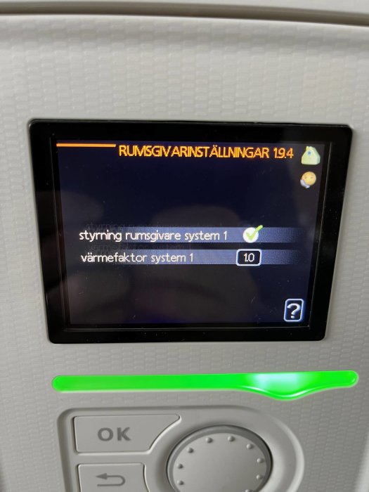 Digital panel visar rumsvärmeinställningar med text på svenska och grönt statusljus nedanför.