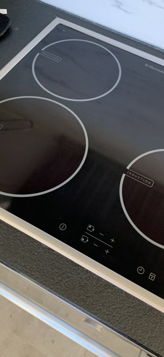 Induktionshäll, svart, modern, touchkontroller, Electrolux logotyp, inbyggd i köksbänk, oanvändskick, köksmiljö.