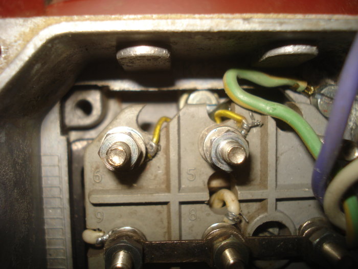 Elanslutningsblock med kablar och terminaler i en elektrisk apparat eller panel.