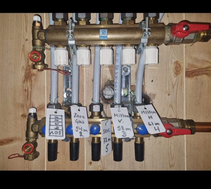 Värmesystem, rör, etiketter, ventiler, manometer, kopplingar, installation, trävägg, regulatorer och instrumentering.