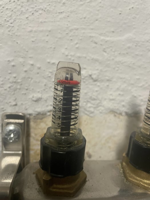 Mätmätare för vätskeflöde, transparent, märkningar i liter per minut, monterad på rör.