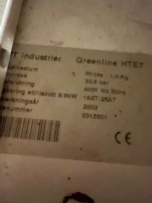 Etikett med teknisk information, modellnamn "Greenline HTE7", spänning, effekt, CE-märkning, delvis suddig.