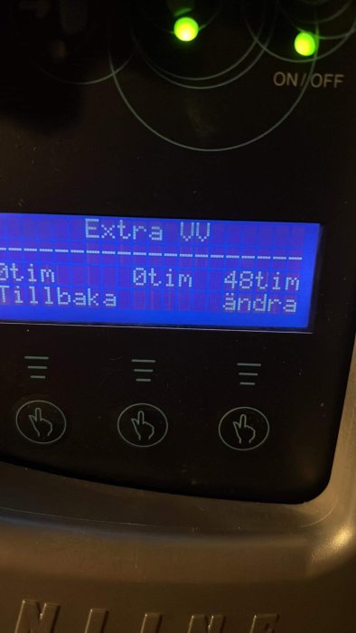 Digital display på apparat med knappar, text "Extra tork", "tid kvar", ljusa indikatorlampor ovanför.