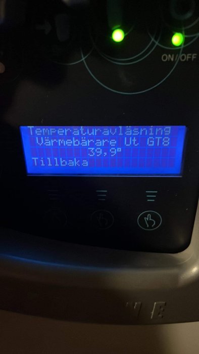 Digital skärm visar temperaturinställning, "Värmebärare Ut GT8 39.9°C", omges av knappar, två gröna indikatorljus aktiva.