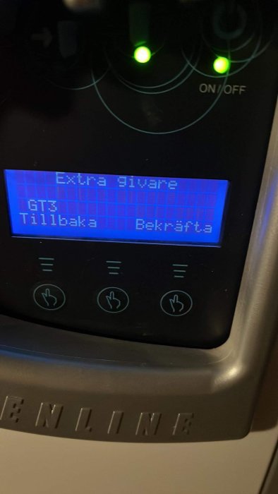 Digital panel på apparat med text, knappar, gröna lysdioder, texten "Extra givare GT3" synlig.