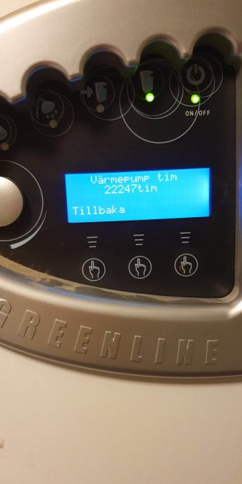 Digital display på värmepump med driftstimmar, knappar och gröna lysdioder för på/av funktion. "Greenline" text synlig.
