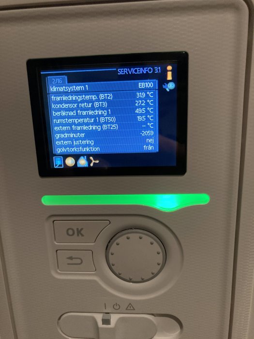 Digital skärm som visar information om klimatsystem ombord på ett fordon eller anläggning, omgiven av kontrollknappar.