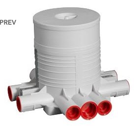 Plastkomponent med cylindrisk kropp, flera rörutlopp, röda insatser. Ser ut som del i VVS- eller bevattningssystem.