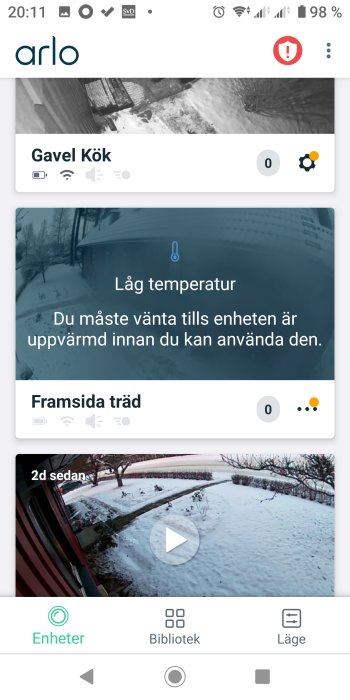 Skärmdump av säkerhetskameraapp, varnar för låg temperatur, två kameravyer med snöscener, text på svenska.