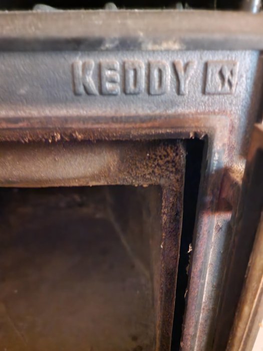 Närbild, gammal rostig metall med texten "REDDY K", oskarp bakgrund.