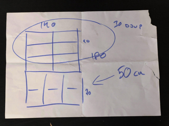 Ritad skiss på vitt papper, blåa linjer, handskrivna måttangivelser, veckat, planlösning eller designutkast.