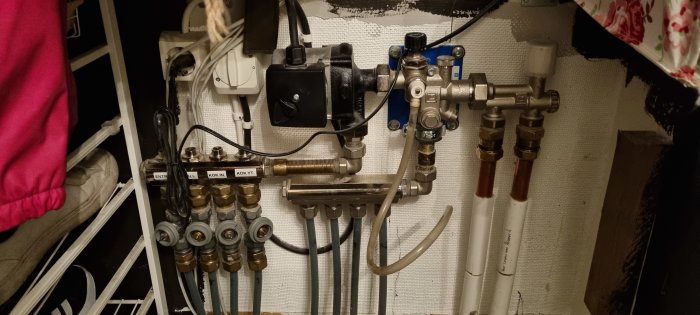 Komplexa rörinstallationer, ventiler och märkta rör för vatten och uppvärmning inomhus. Oorganiserad, kluster av ledningar.