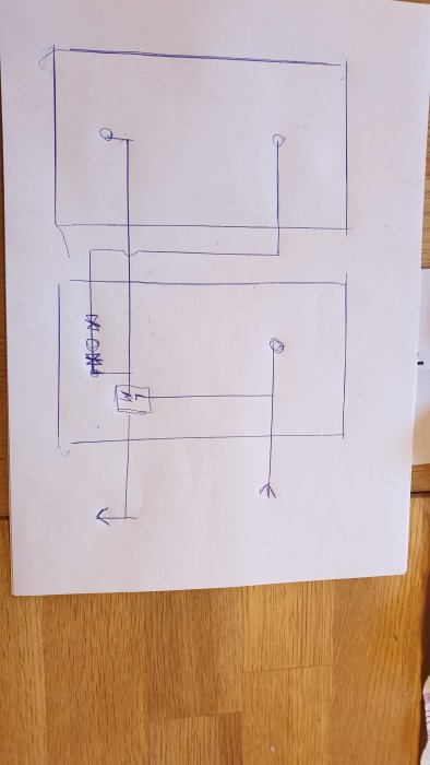 Enkel handritad skiss av en elektrisk krets eller layout med symboler för komponenter på papper.