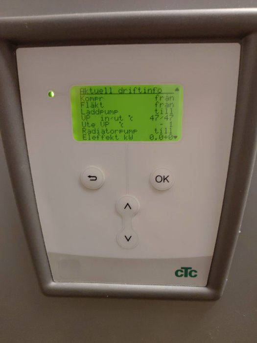 Digital kontrollenhet för värmesystem med temperatur- och driftinformation på svensk samt knappar och OK.