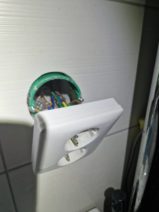 Elektrisk vägguttag utan täckplatta exponerar trådar, installationsbox, behöver reparation eller färdigställande, säkerhetsrisk.