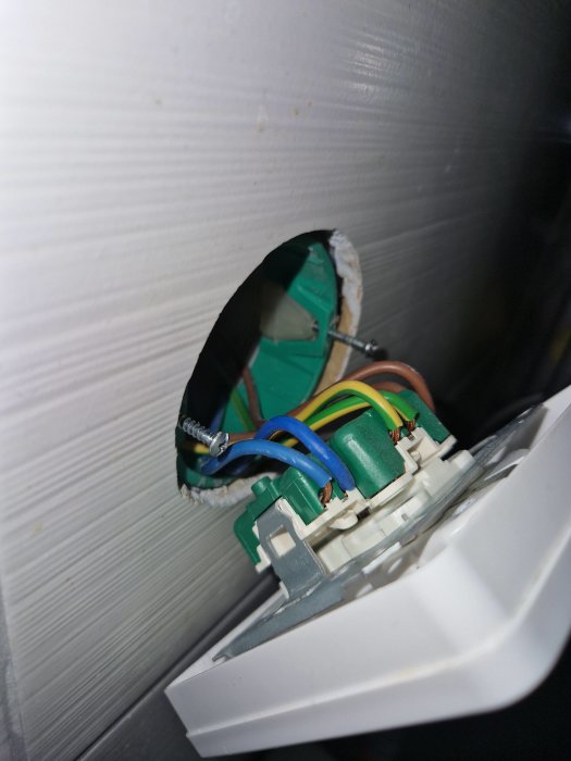 Öppen elinstallation, oskyddade elkablar och anslutningar, väggmonterad strömbrytare, säkerhetsrisk, oavslutat elektriskt arbete.