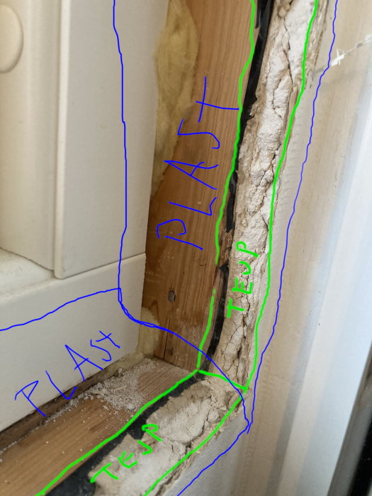 Skadad träram på dörr eller fönster med isoleringsskum och markeringar.