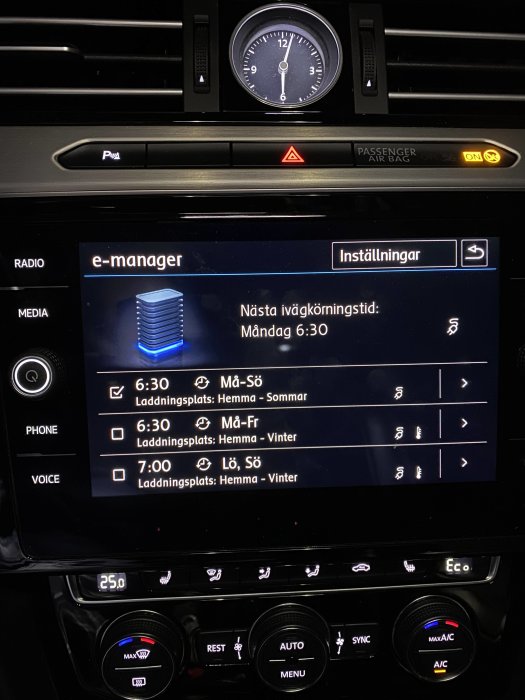 Bilens infotainmentsystem visar laddningsschema för elektrisk fordon, klocka och klimatkontrollinställningar.