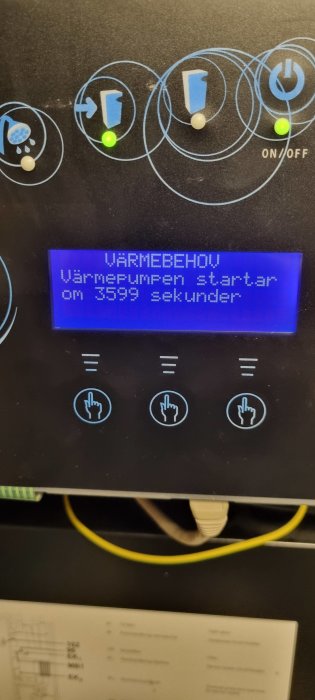 Kontrollpanel för värmepump med LCD-skärm som visar nedräkning på svenska. Knappar och ljust indikerings-LED.