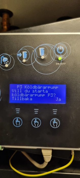 Kontrollpanel med knappar, statusindikatorer, och LCD-skärm. Text på svenska, frågar om start av kylbärarpump.