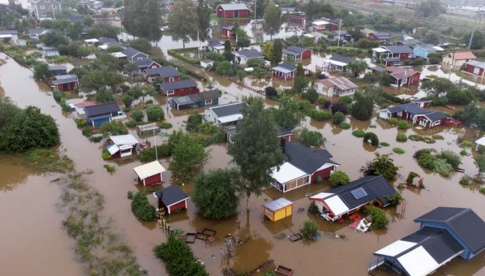 Område översvämmat, hus och trädgårdar under vatten, katastrof, akut situation, naturkraft visar sig, evakueringsbehov.