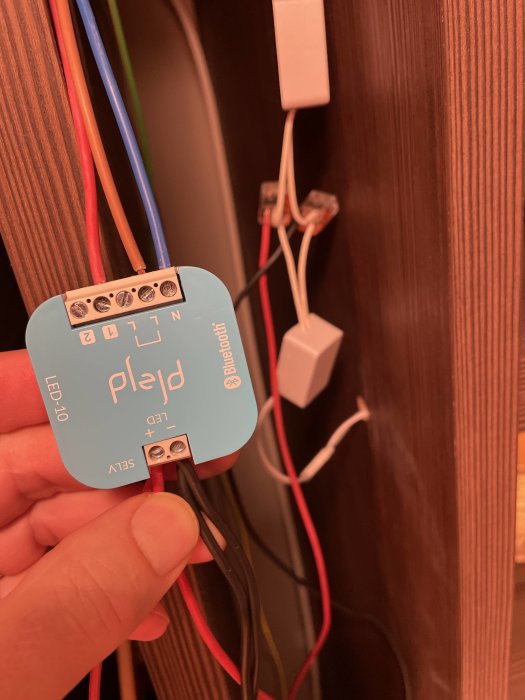 Elektrisk installation med ledningar, anslutningsklämmor och en strömfördelare mot en träbakgrund.