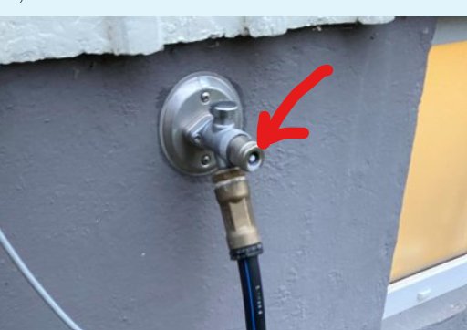 Väggmonterad vattenkran med ansluten slang. Röd pil pekar på kranen. Grå fasad, uteplatsmiljö.