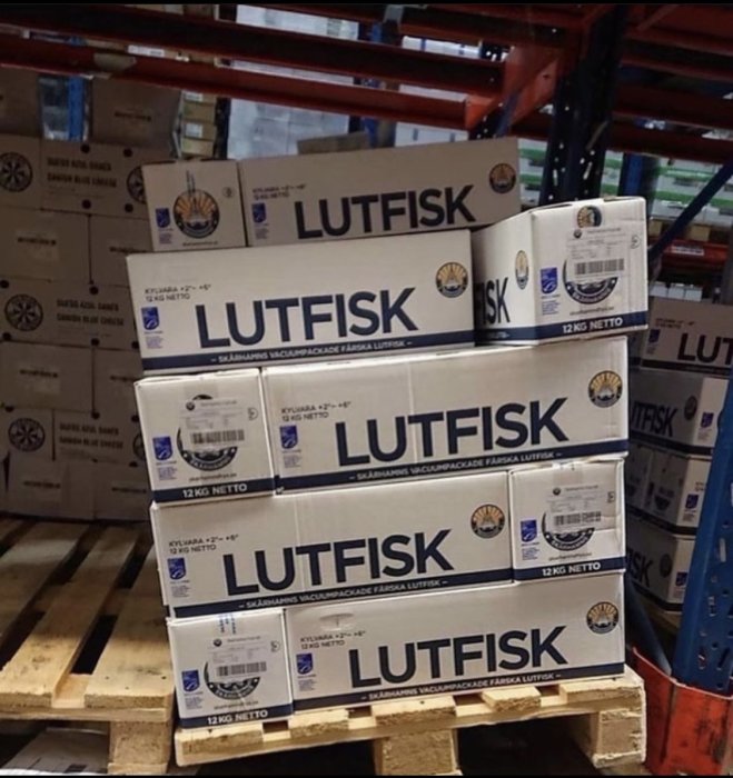 Staplar av förpackade lutefisk-kartonger på pall i ett lager.