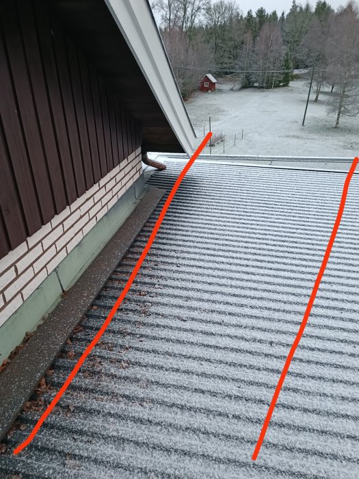 Ett frostigt tak sett från ett hus, med snörikt landskap och ett rött hus i bakgrunden.