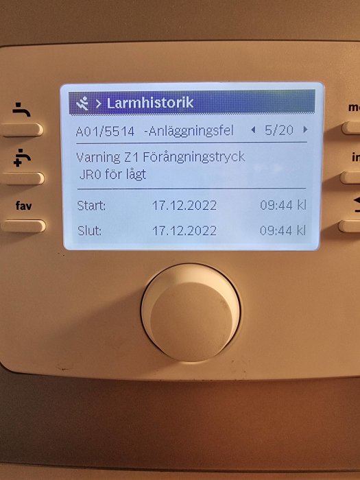 Skärm med alarmhistorik på vit apparat; visar felmeddelande, datum och tid.